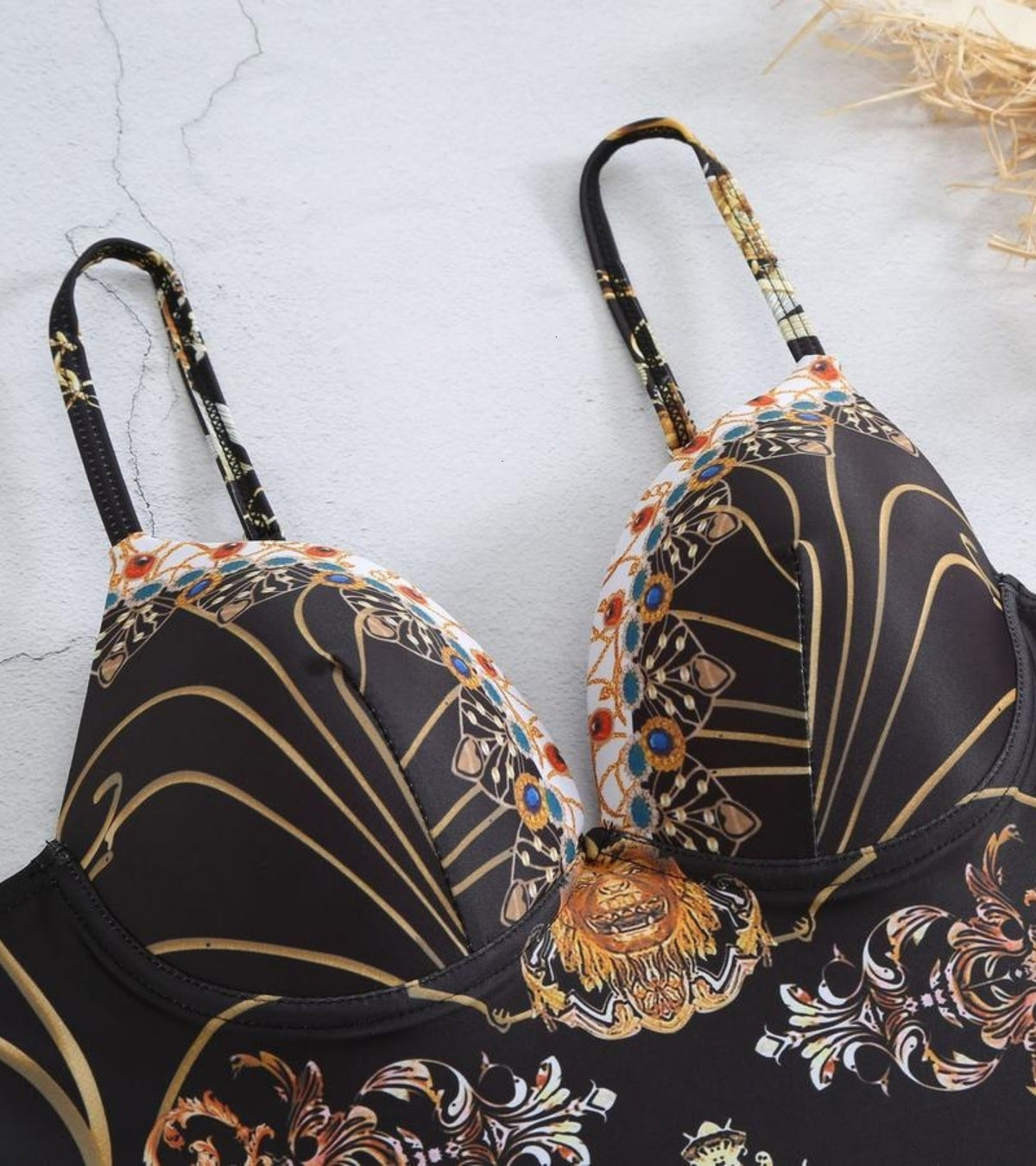 One-piece swimsuit close-up, black molded cups with gold and floral baroque print