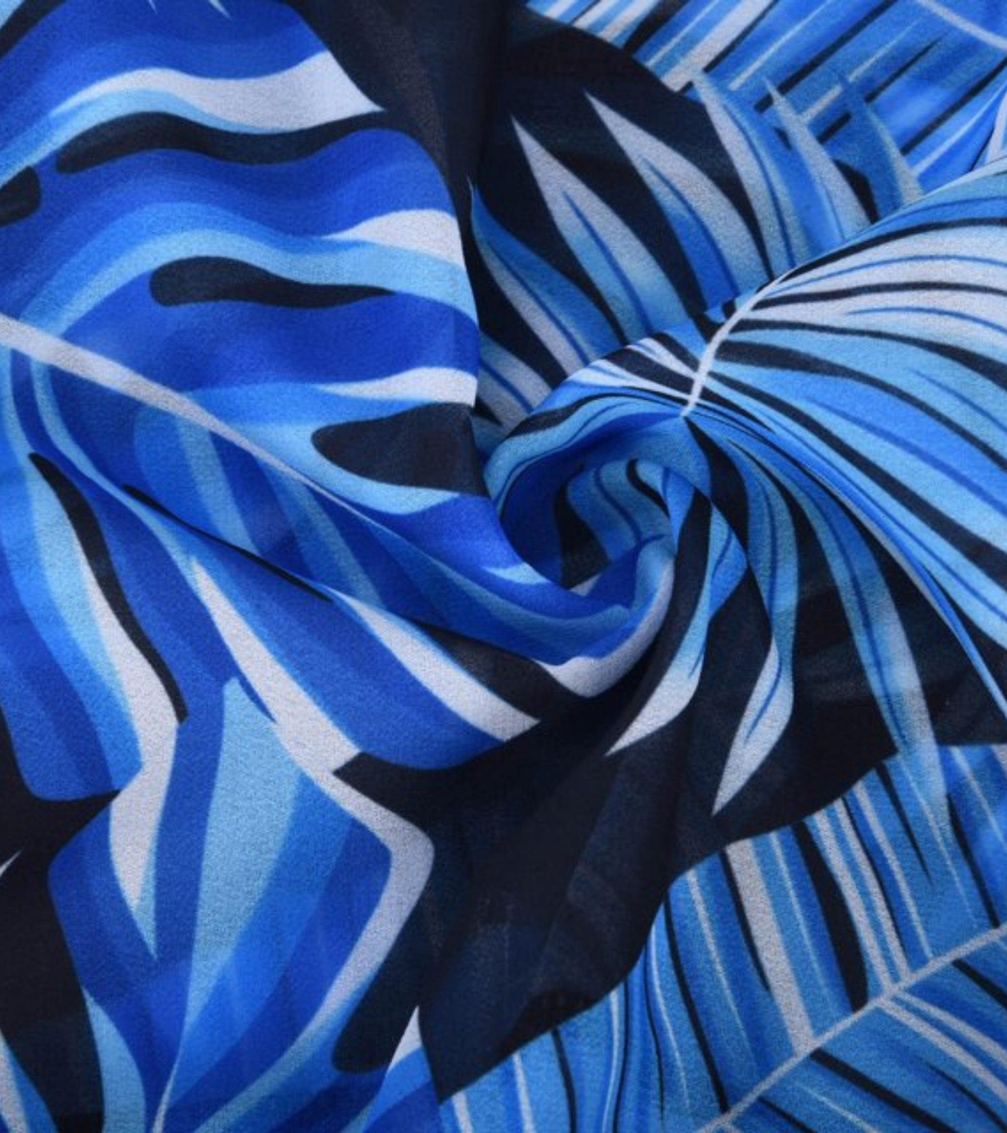 Blue and black tropical leaf and wave print fabric swatch for a swimsuit set.
