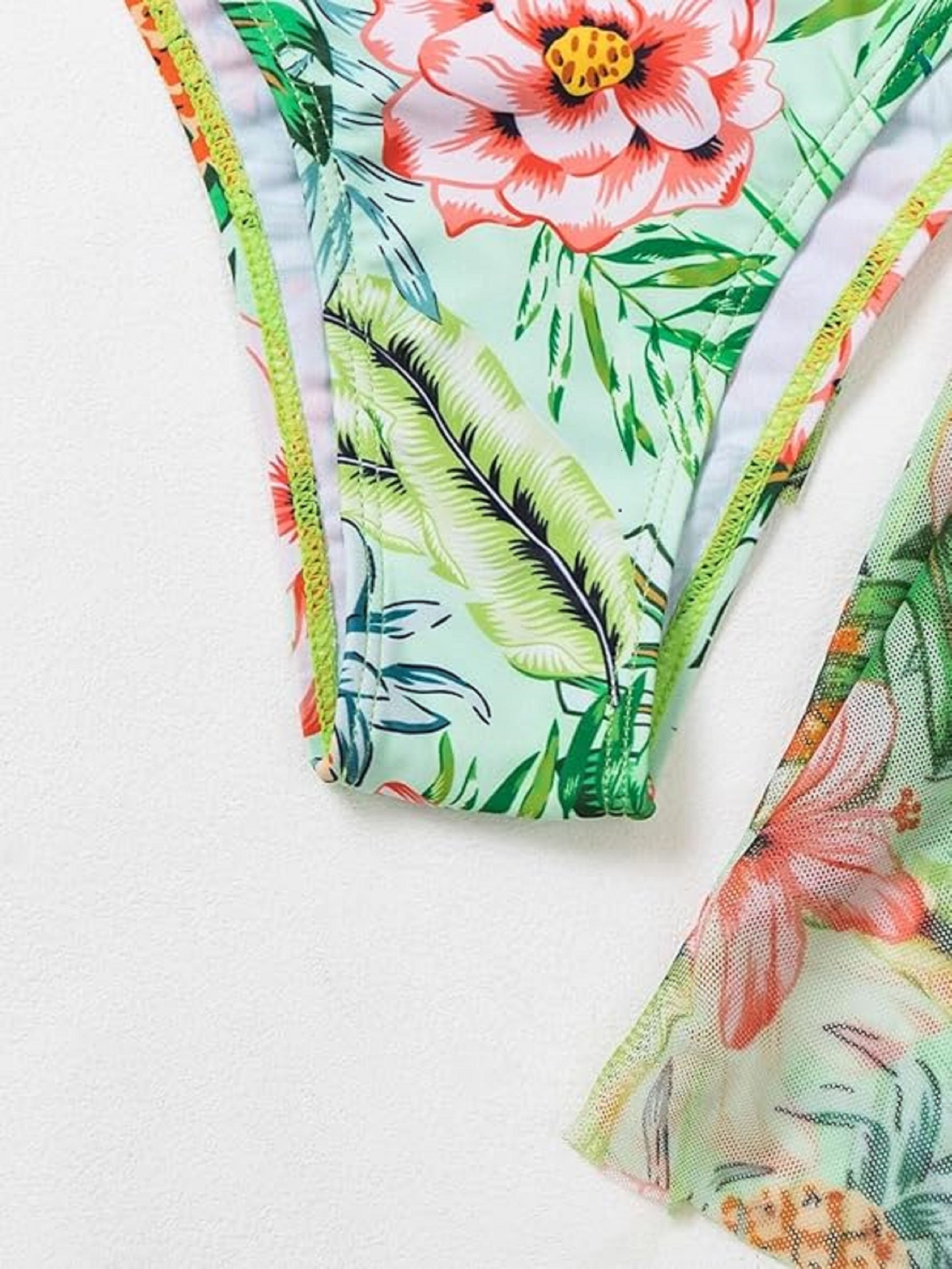 Printed bikini bottom in tropical leaf pattern with multicolor trim edges.