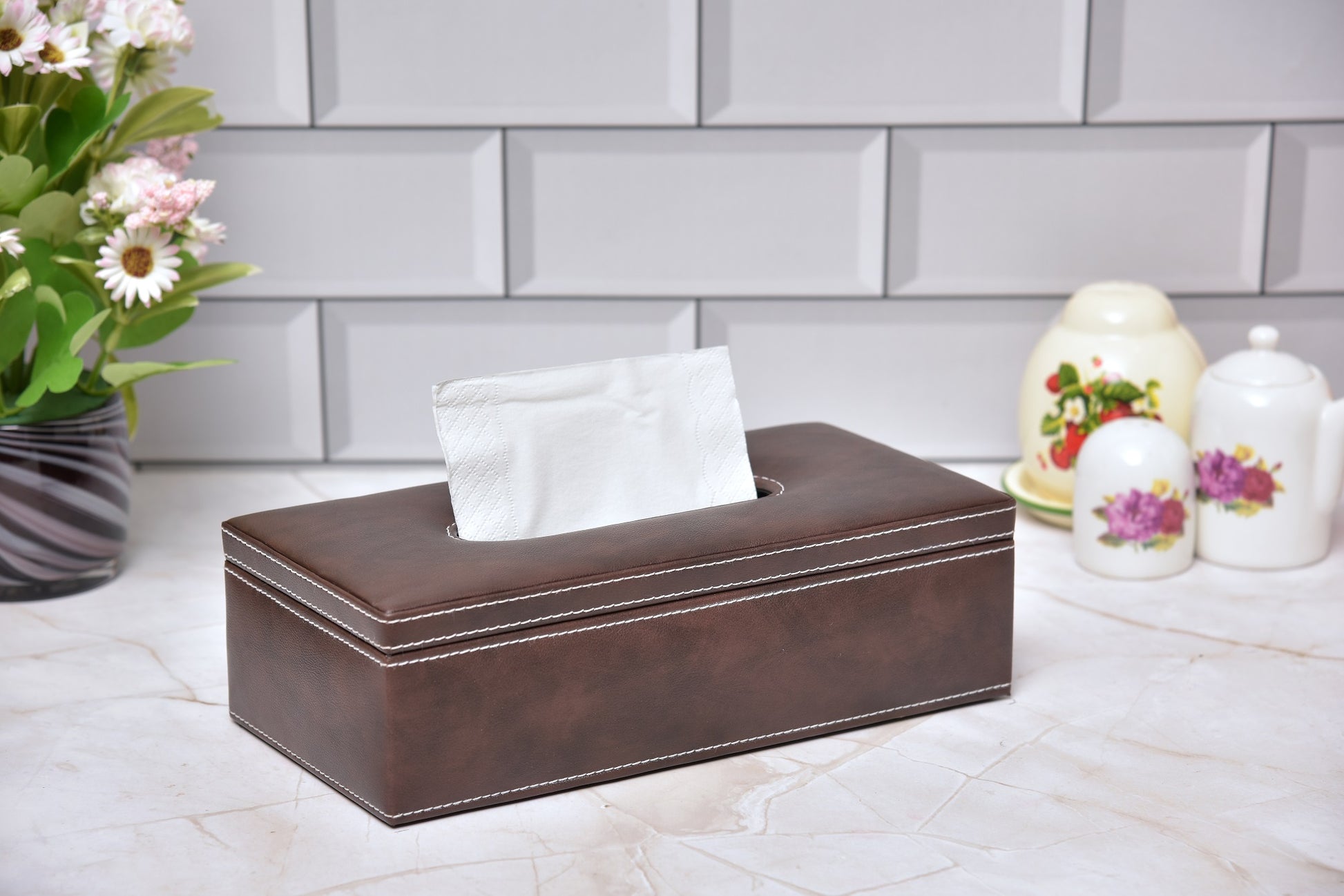 Rectangular tissue holder in brown leatherette with tissue protruding, front view