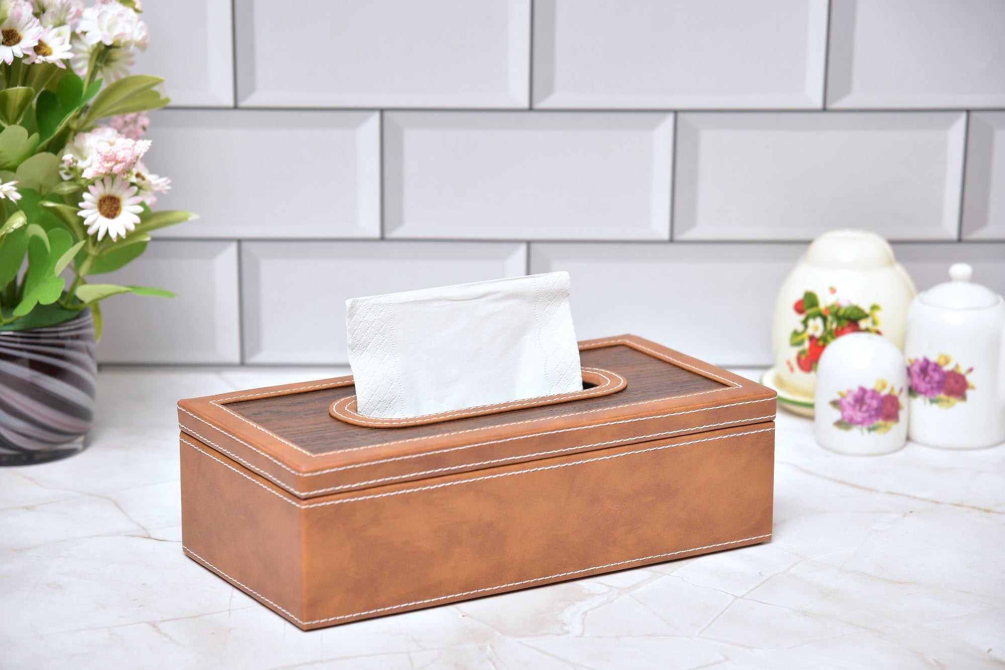 Rectangular tissue box holder with orange leatherette body and wooden-look top, tissue visible