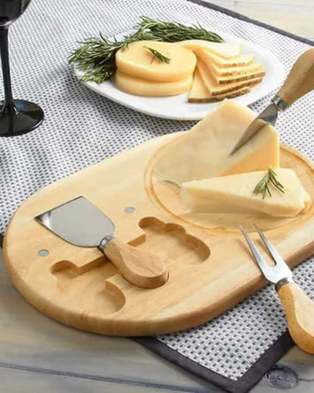 Bamboo oval cheese board with carved slots and cheese knives, on a serving surface