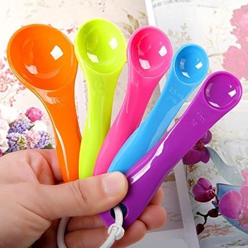 Rainbow measuring spoons set with hand holding a purple spoon from the group