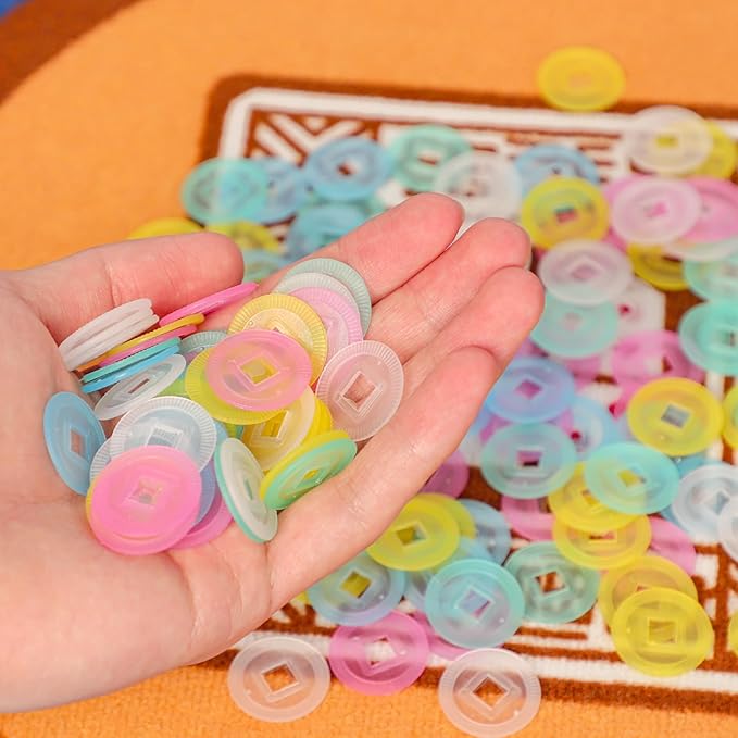 Hand holding multicolor translucent mahjong scoring chips with raised center icons