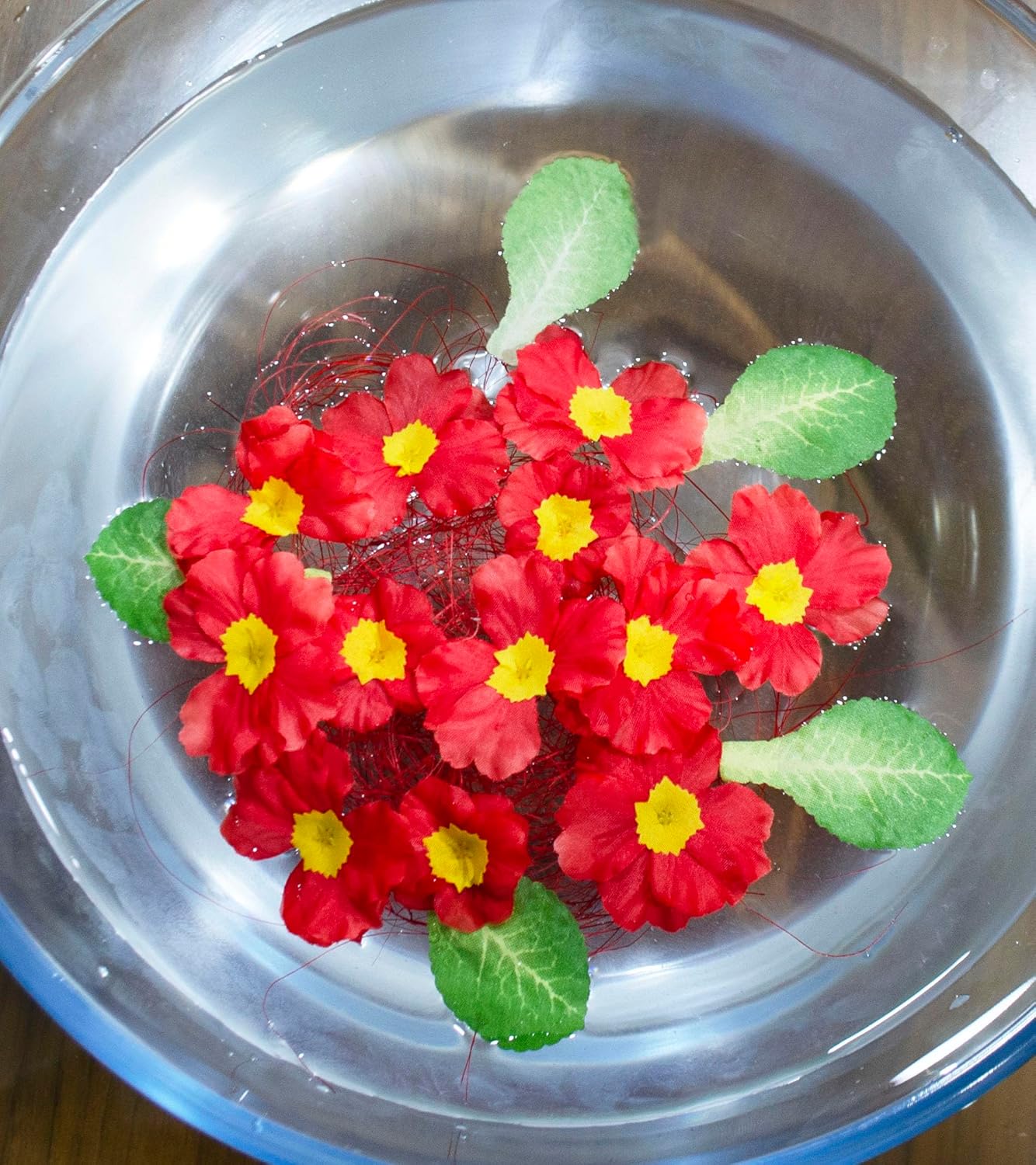 Artificial floating flower shrub in water bowl, red blooms with yellow centers