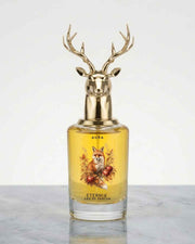 Glass eau de parfum bottle with gold deer antler cap, yellow liquid, front labels