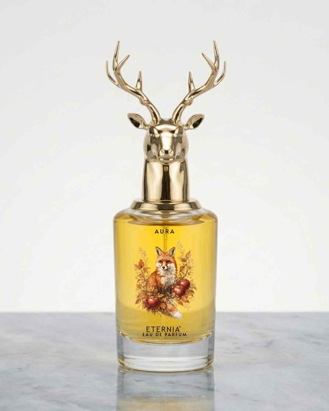 Glass eau de parfum bottle with gold deer antler cap, yellow liquid, front labels
