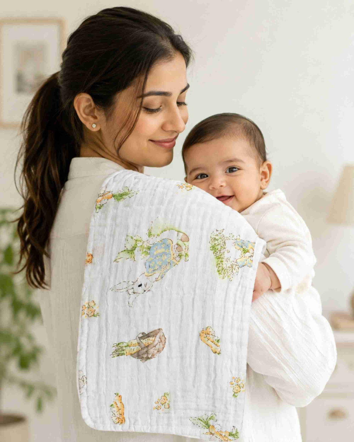 White burp cloth in parent’s arms with quilted texture and bunny, carrot garden print