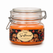 Unlit jar candle with orange wax in clear glass, metal clamp handle, floral label
