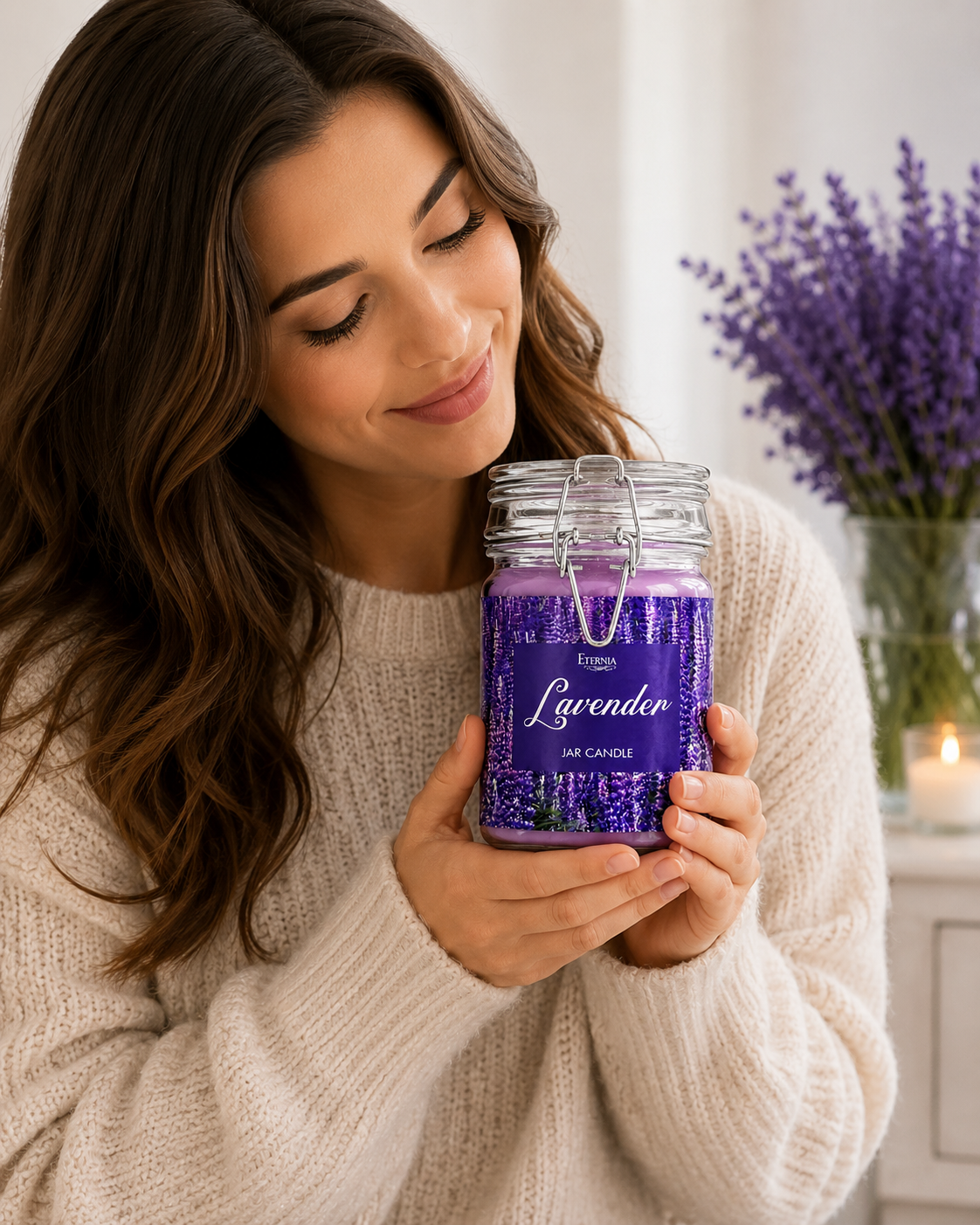 Lavender jar candle held in hand, clear glass with purple wax and gold label