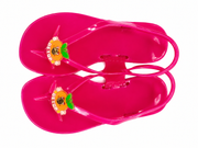 Pink jelly sandals with back strap, side view and decorative charm on strap.