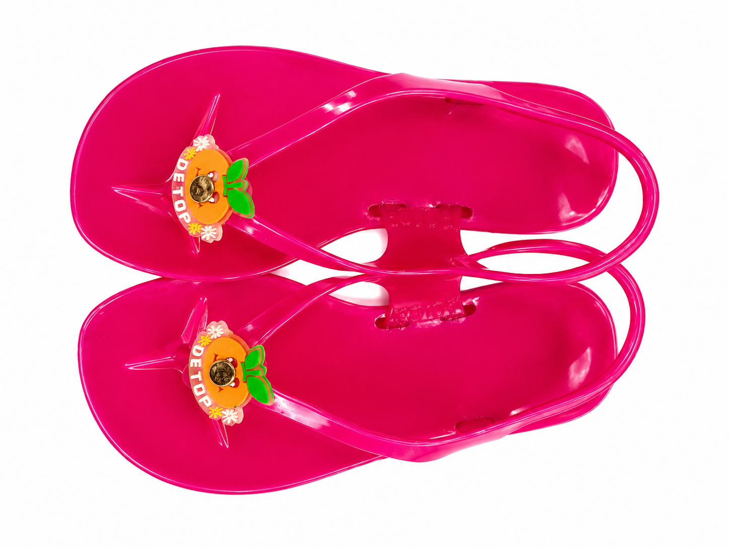 Pink jelly sandals with back strap, side view and decorative charm on strap.