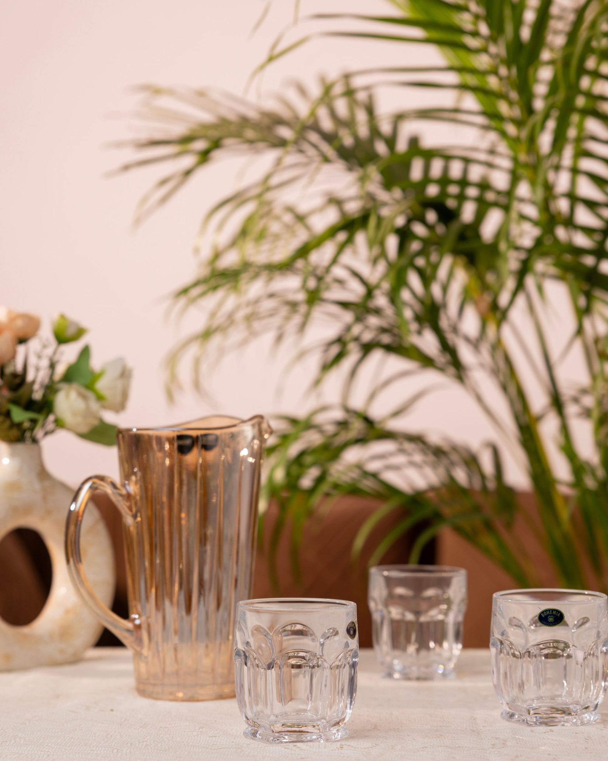 Amber glass water jug with faceted crystal tumblers, matching short glasses