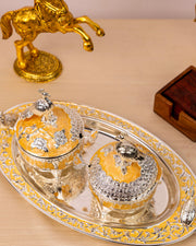 Ornate covered serving bowls on decorative tray with peacock finials, gold and silver