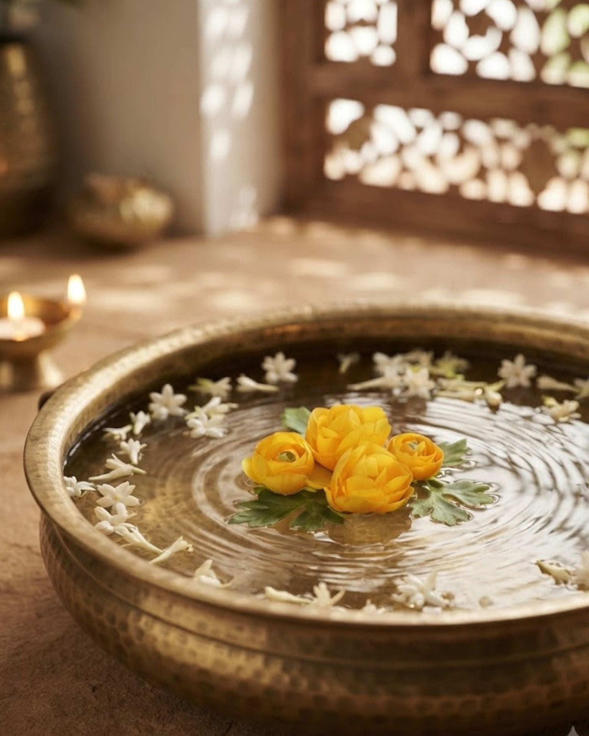 Artificial floating yellow rose flowers in a round tray with scattered white petals