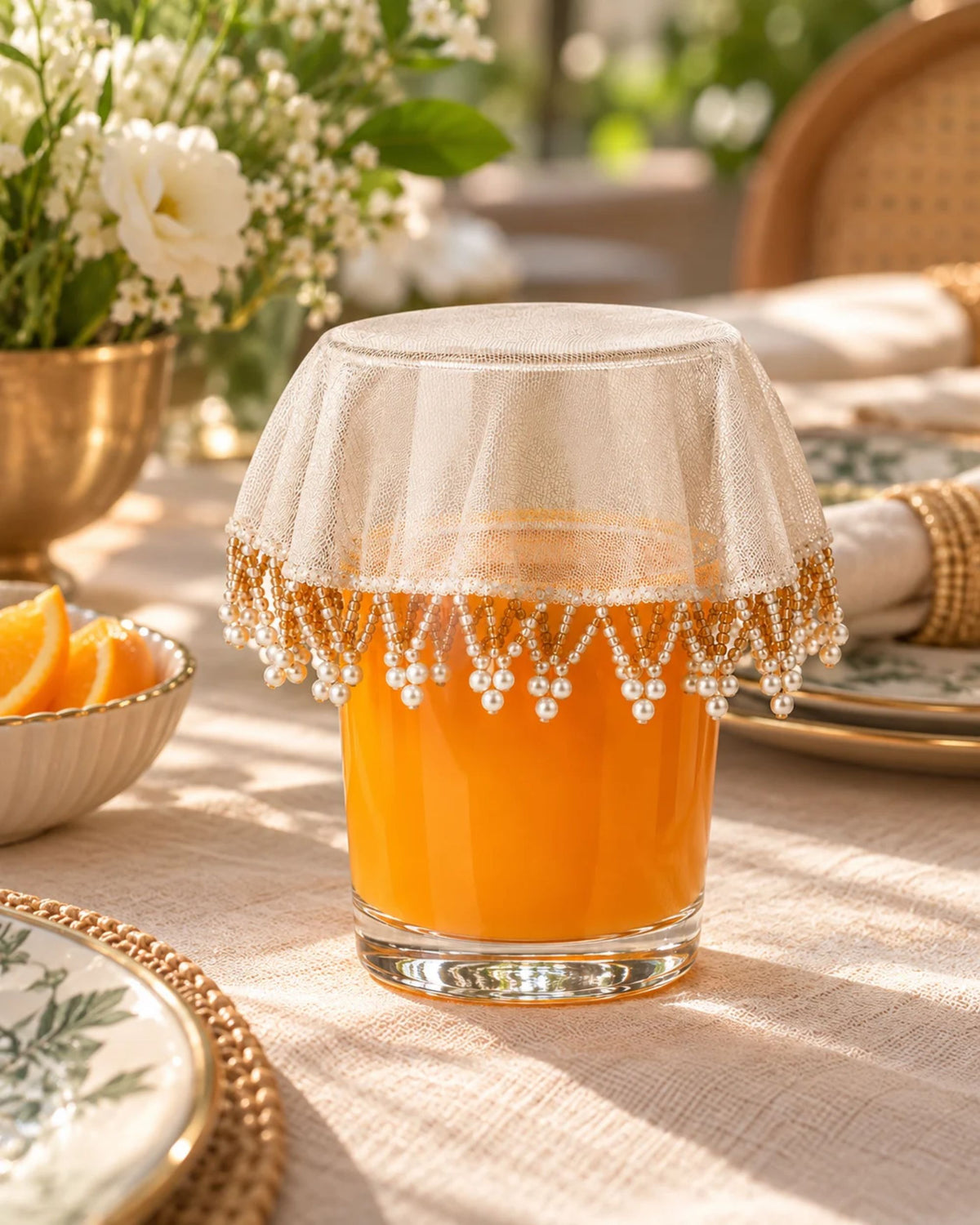 Cream net drink glass cover with golden lace-like band and dangling bead fringe