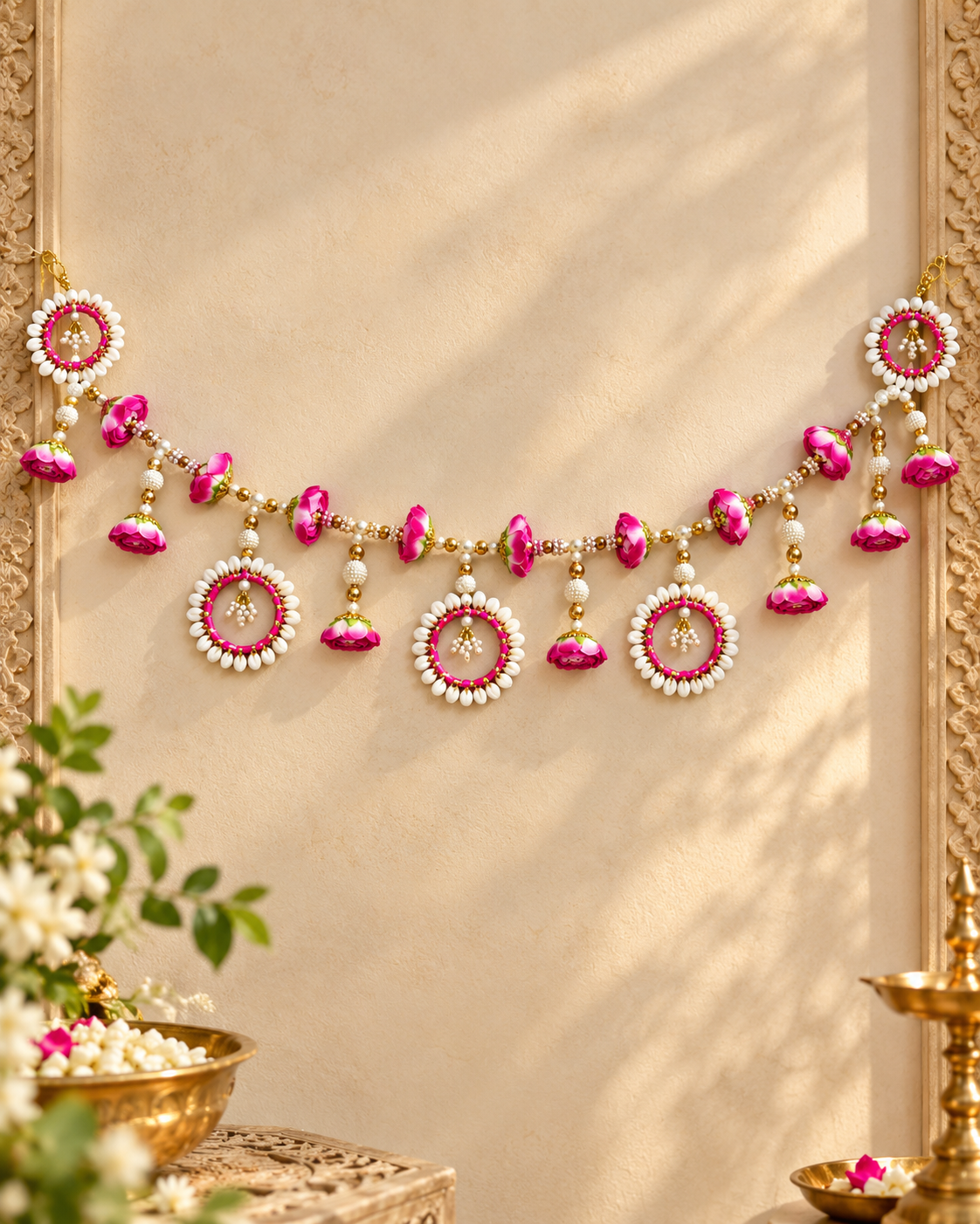 Decorative floral door toran with pink bells, pearl beads, and tassels