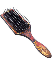 Floral paddle hair brush with black bristles and wooden handle, orange-brown patterned cushion