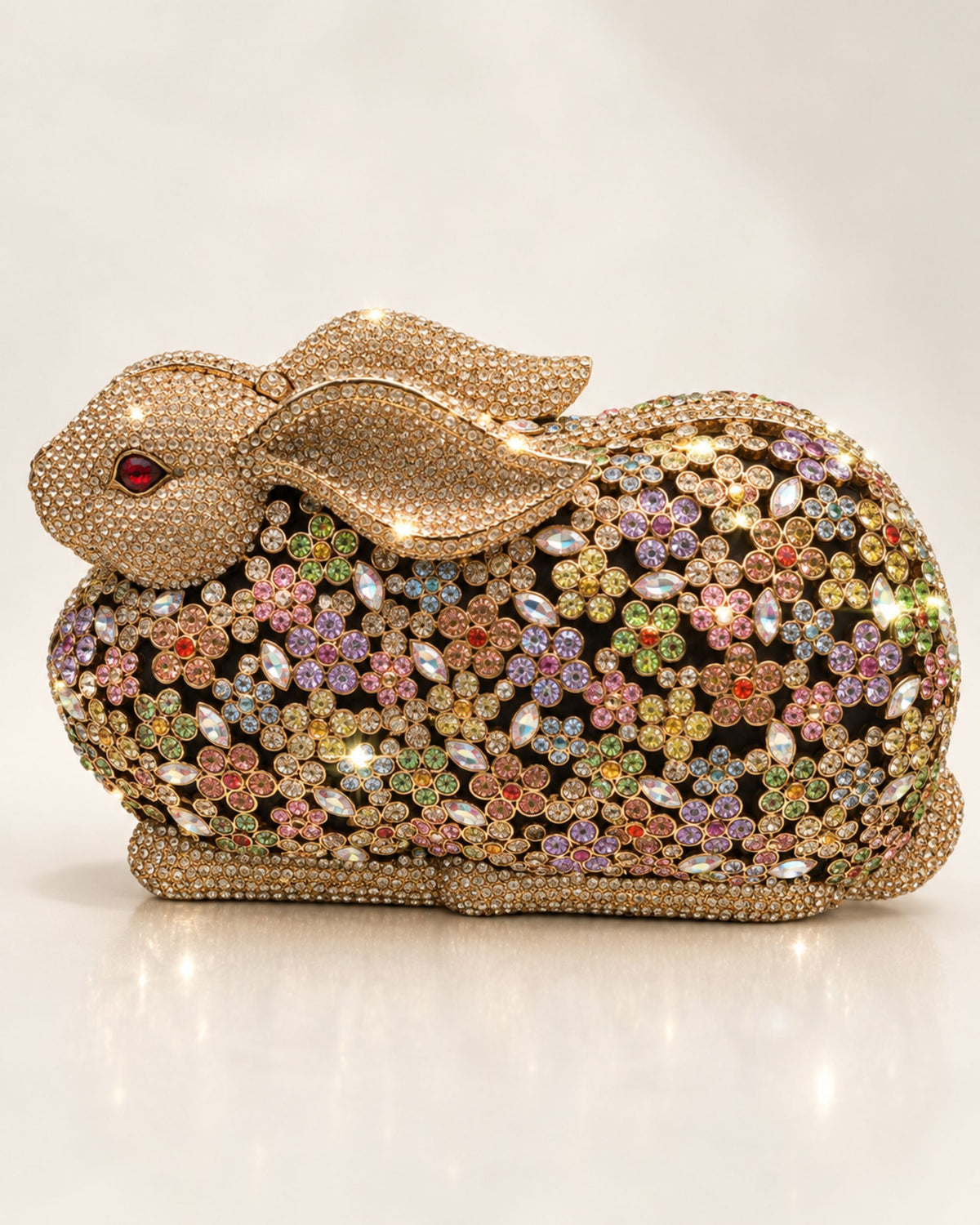 Gold crystal rabbit clutch with jeweled multicolor button eyes and rhinestone shell