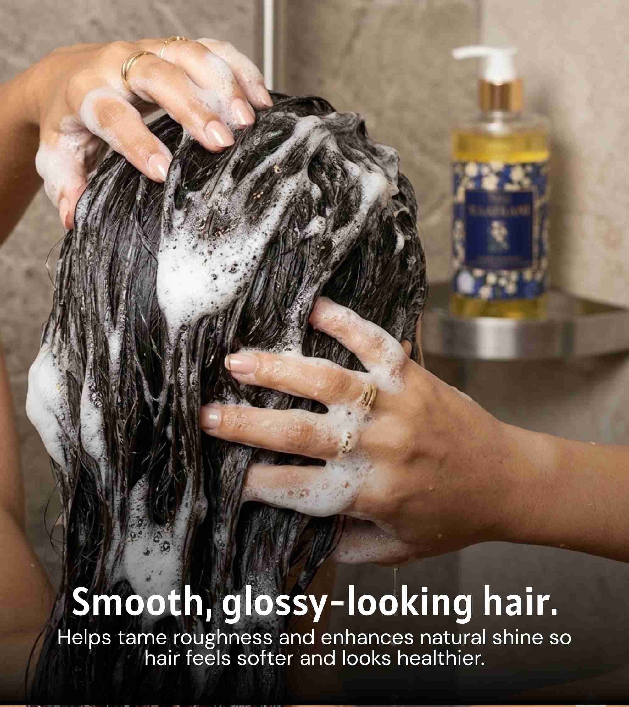 Shampoo lather on dark hair with hands massaging; Raatrani shampoo bottle nearby