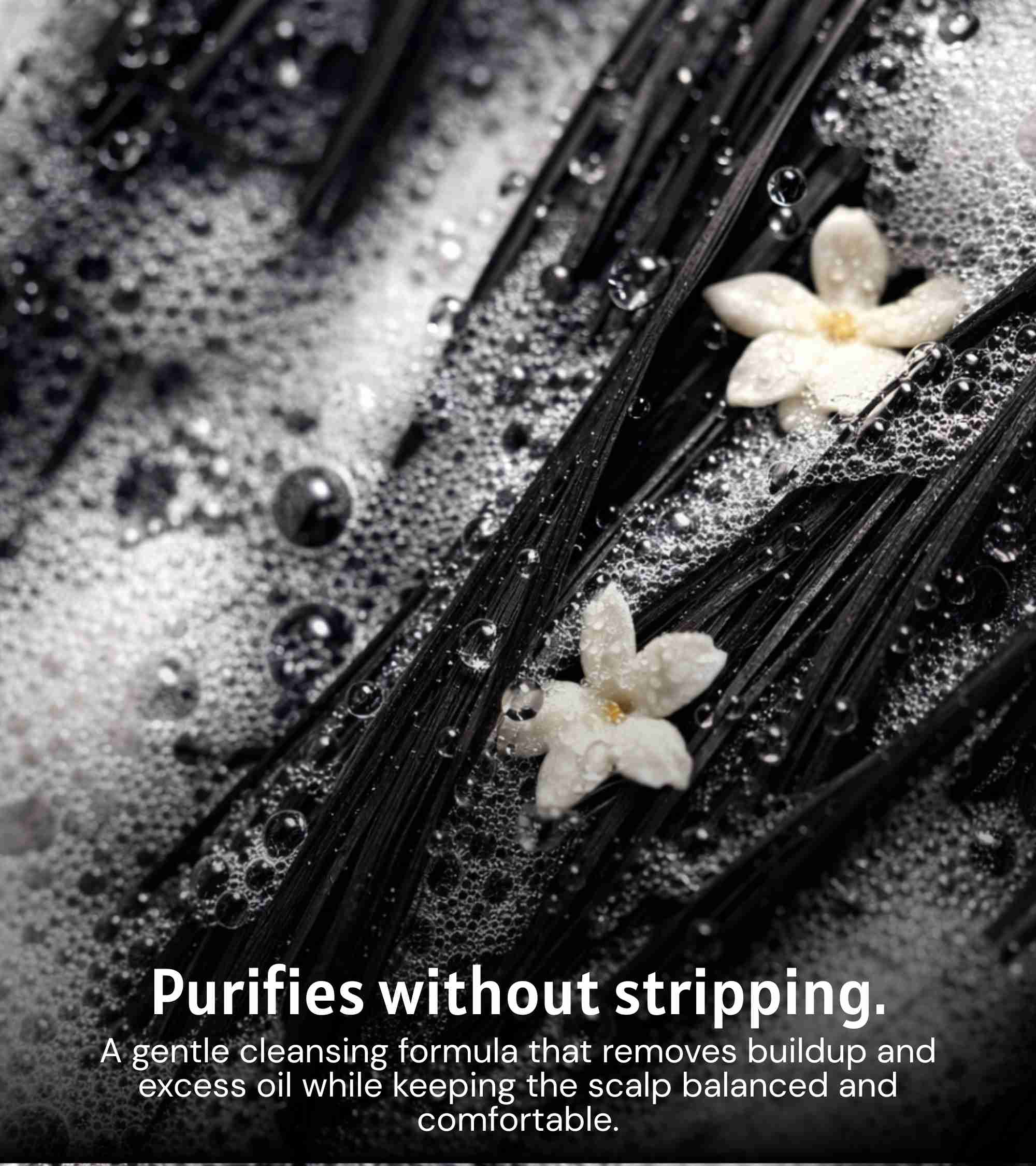 Wet dark hair strands with water droplets and white moonflower petals
