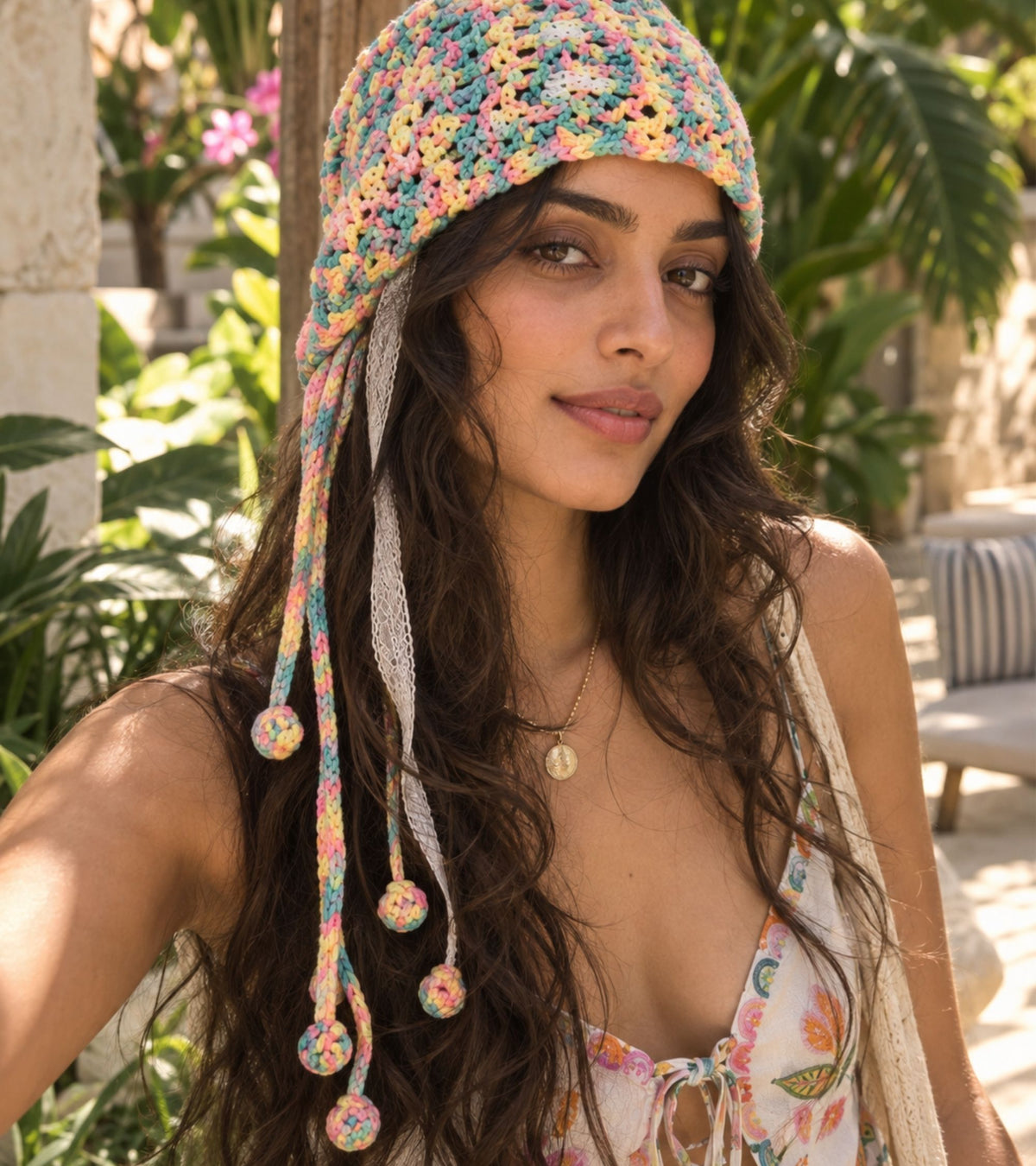 Multicolor crochet beanie with long lace panels and pom tassels, pink-toned