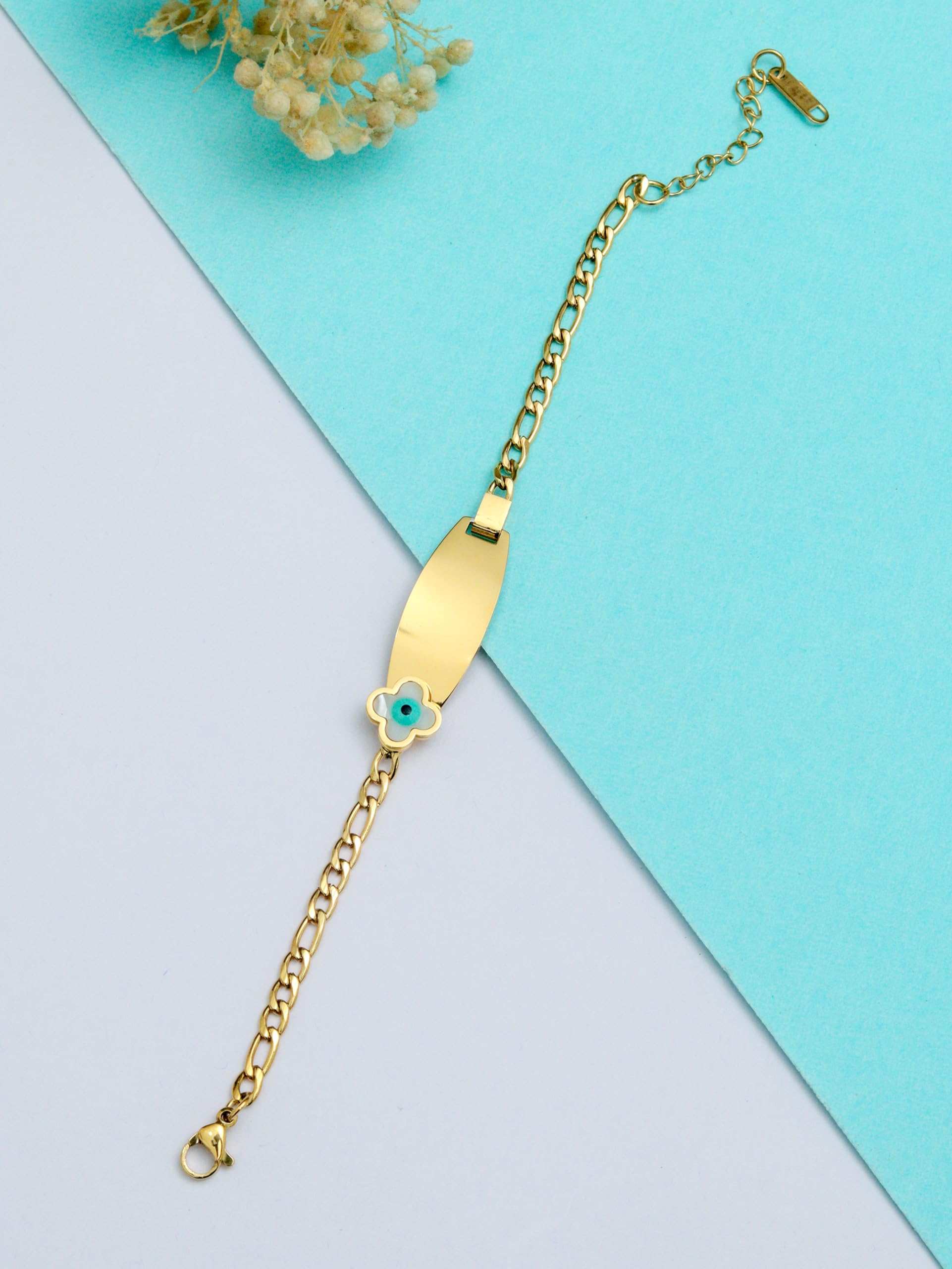 A gold-plated bracelet with an evil eye charm and a flower detail, displayed against a two-tone blue and white background.