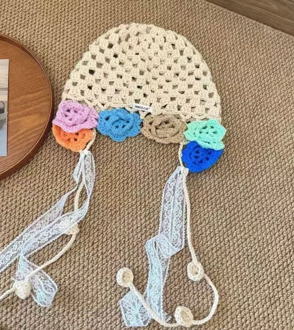 Beige crochet cap detail: multicolor flowers with long lace tassel ties