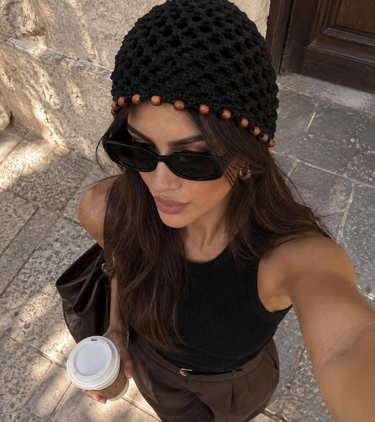 Black crochet beanie with brown beaded trim, worn with sunglasses