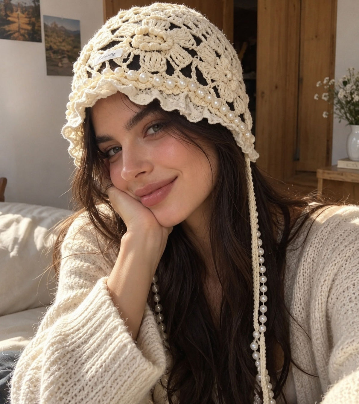 White lace crochet cap with pearl bead trim worn by model, tassel strands visible