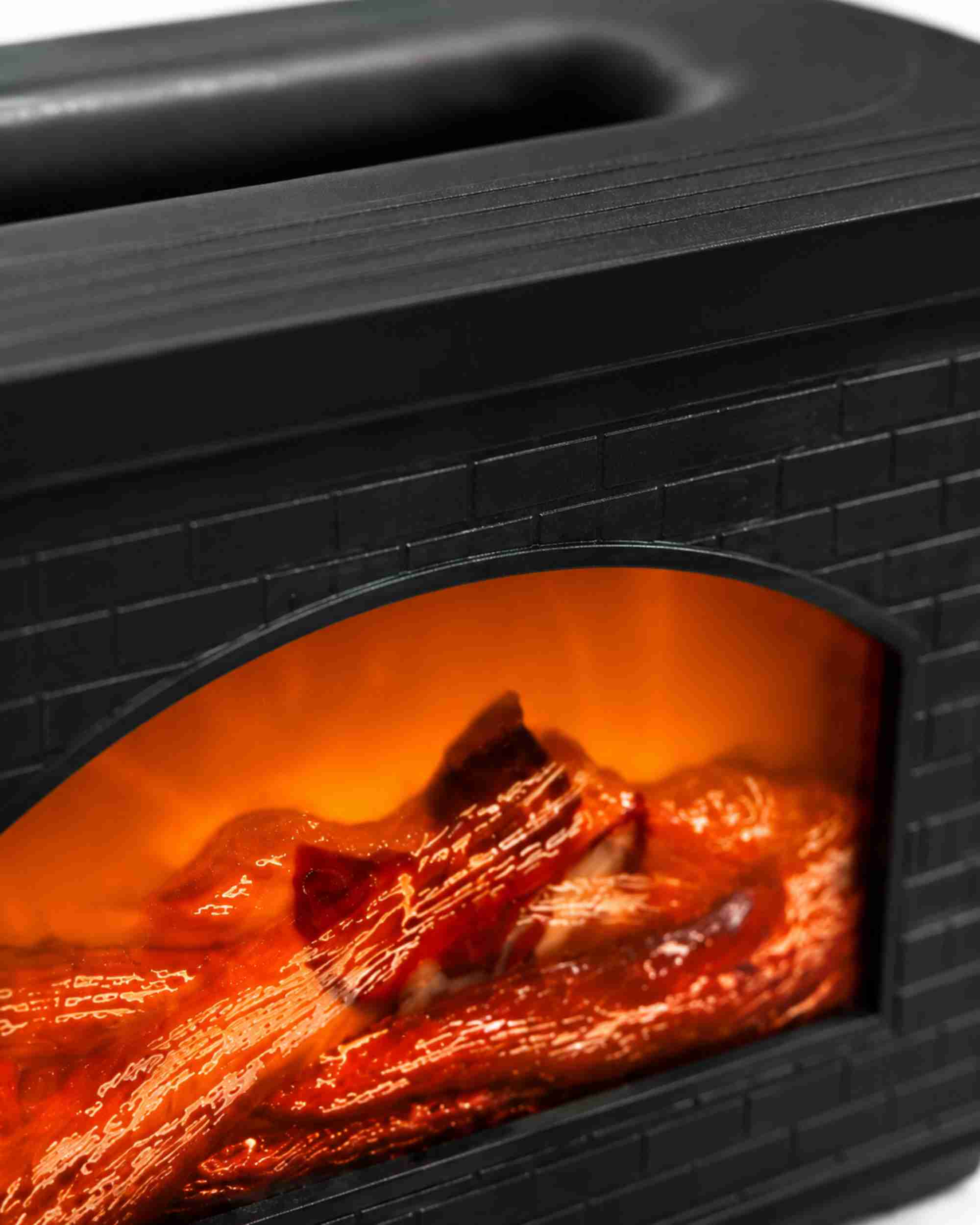 Close-up of black brick flame aroma diffuser window with glowing orange log effect