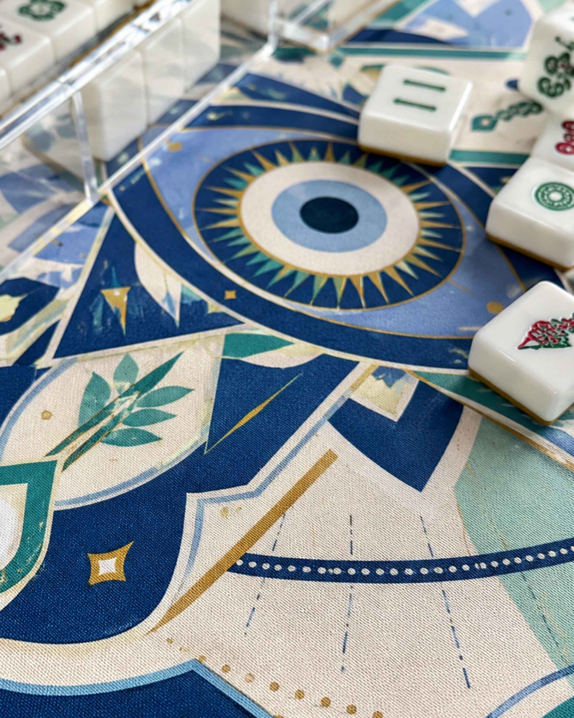 Evil-eye mahjong table mat close-up, blue round evil-eye emblem on patterned surface