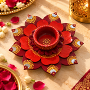Flower-shaped wax diya with red petals and orange-gold decorative pattern