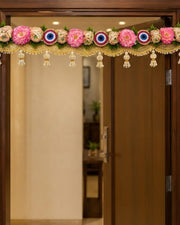 Floral toran door hanging with pink flowers, evil-eye motifs, and hanging bead tassels