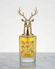 Floral perfume bottle with gold deer antler cap and yellow glass, floral label on front