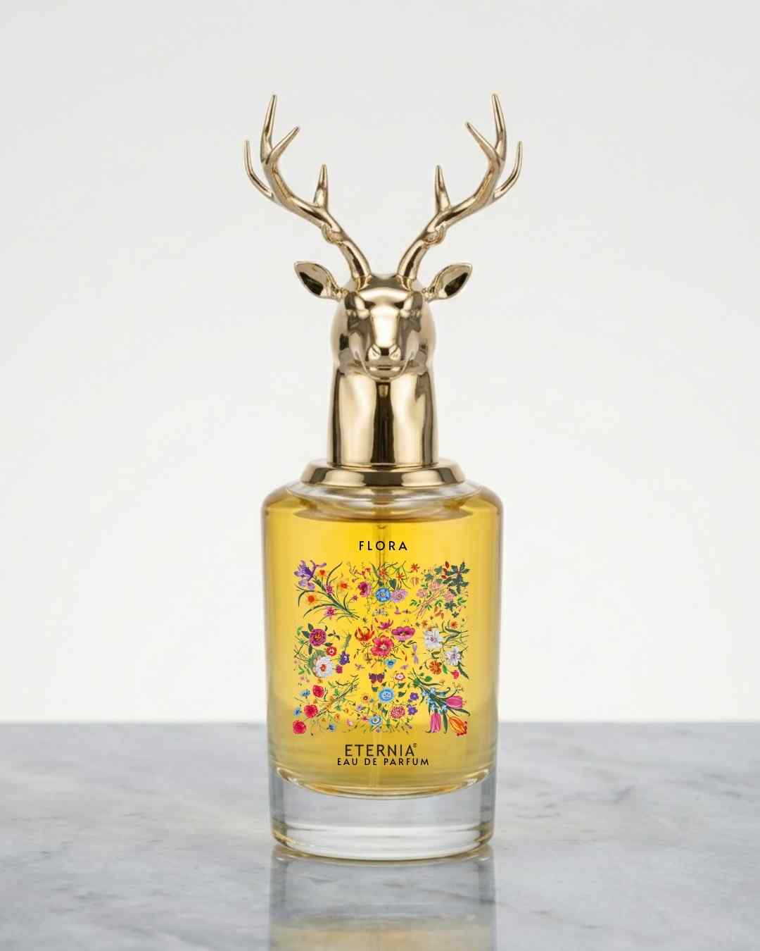 Floral perfume bottle with gold deer antler cap and yellow glass, floral label on front