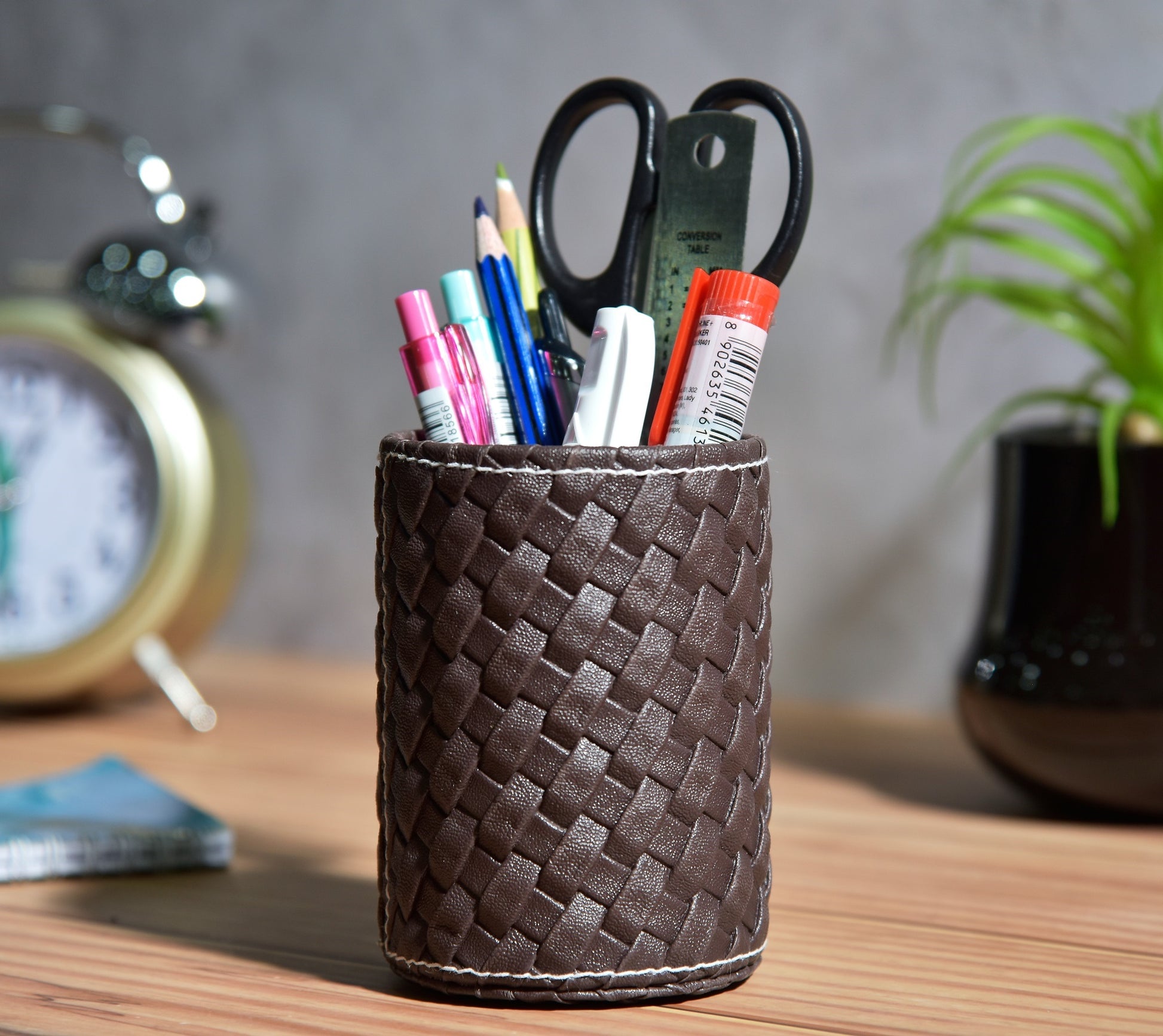 Woven faux leather pen stand, dark brown with desk stationery and scissors inside.