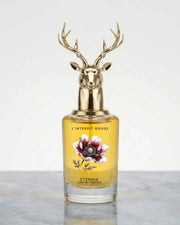 Gold deer-head perfume bottle with antler cap and amber glass, floral label