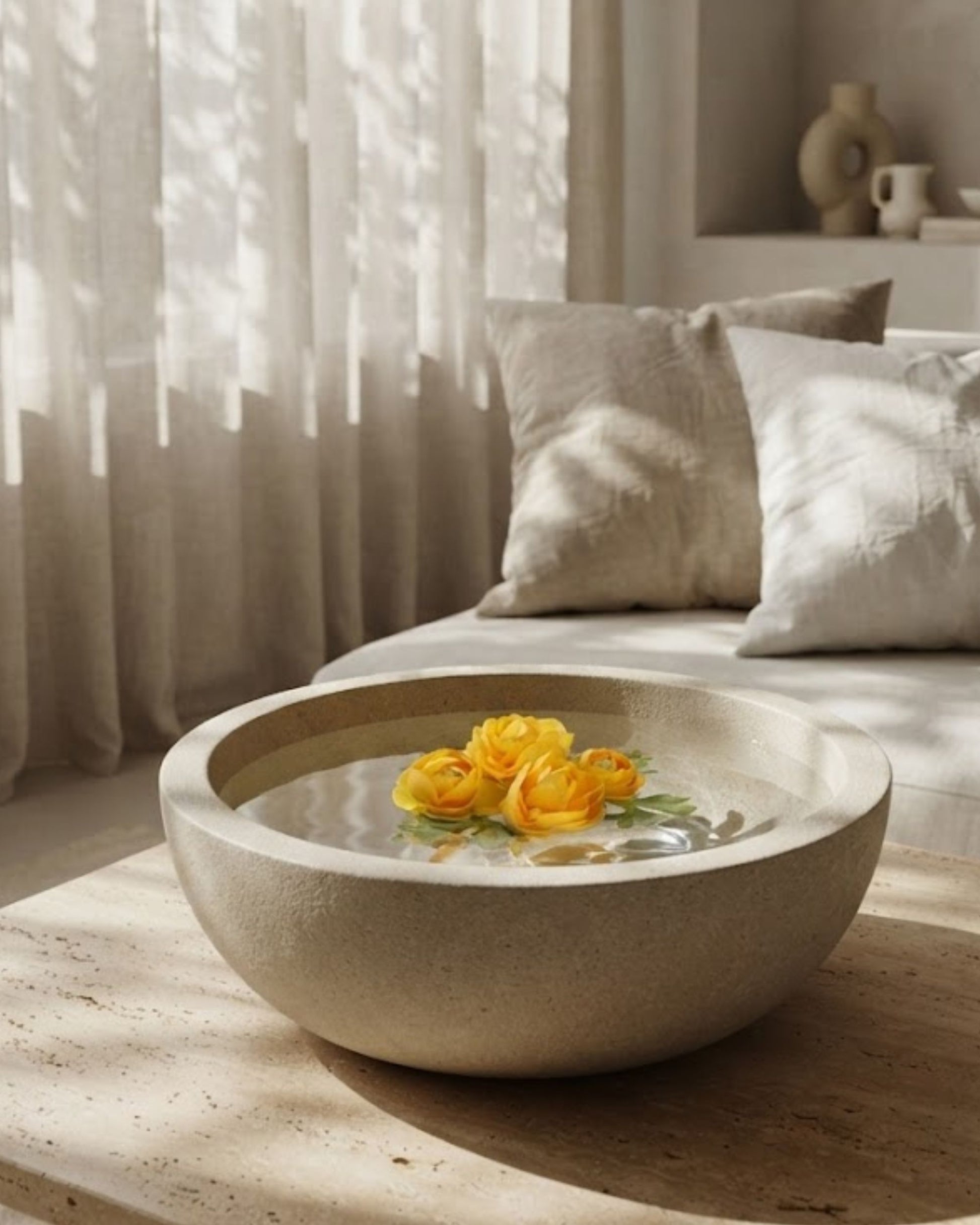 Artificial floating yellow rose flowers in a shallow decorative bowl with water