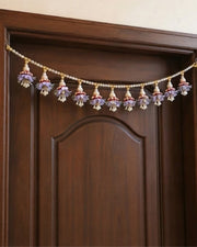 Lavender floral pearl toran garland strung across the top of a wooden door