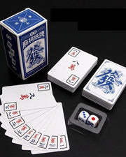 Mahjong playing cards with blue box, stacked cards, and two dice in a tray