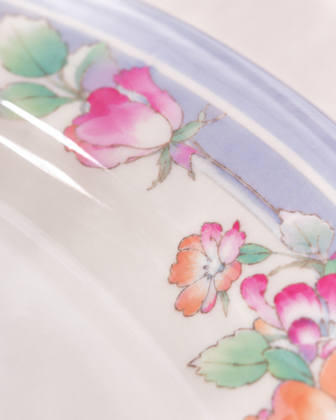 Oval plate rim with pastel pink and orange flower pattern on blue edge