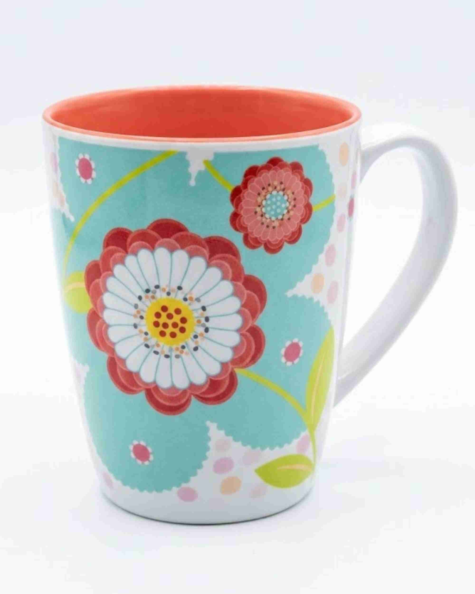 Ceramic mug with teal floral pattern and red/white flowers, white handle.