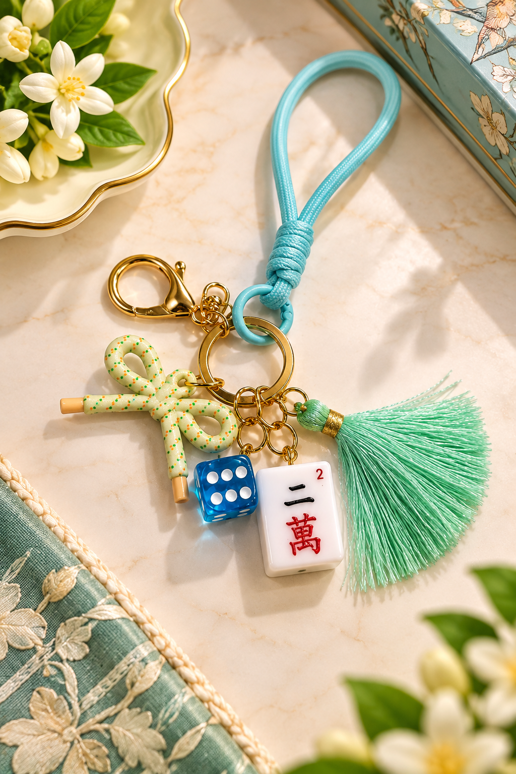Mint mahjong tile keychain with blue tile charm, mint cord loop, and green tassel
