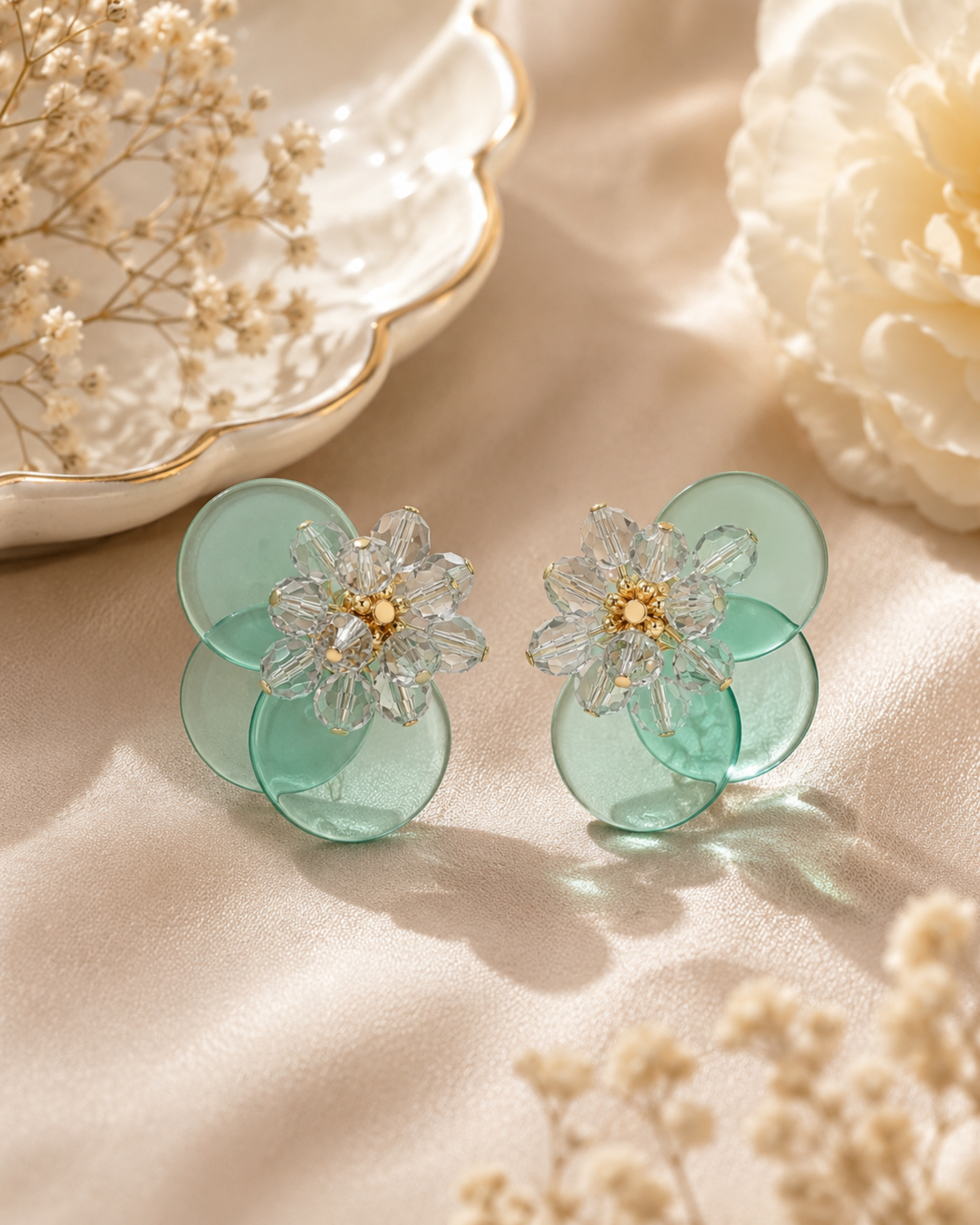 Mint green floral statement earrings with crystal flower centers and layered translucent petals