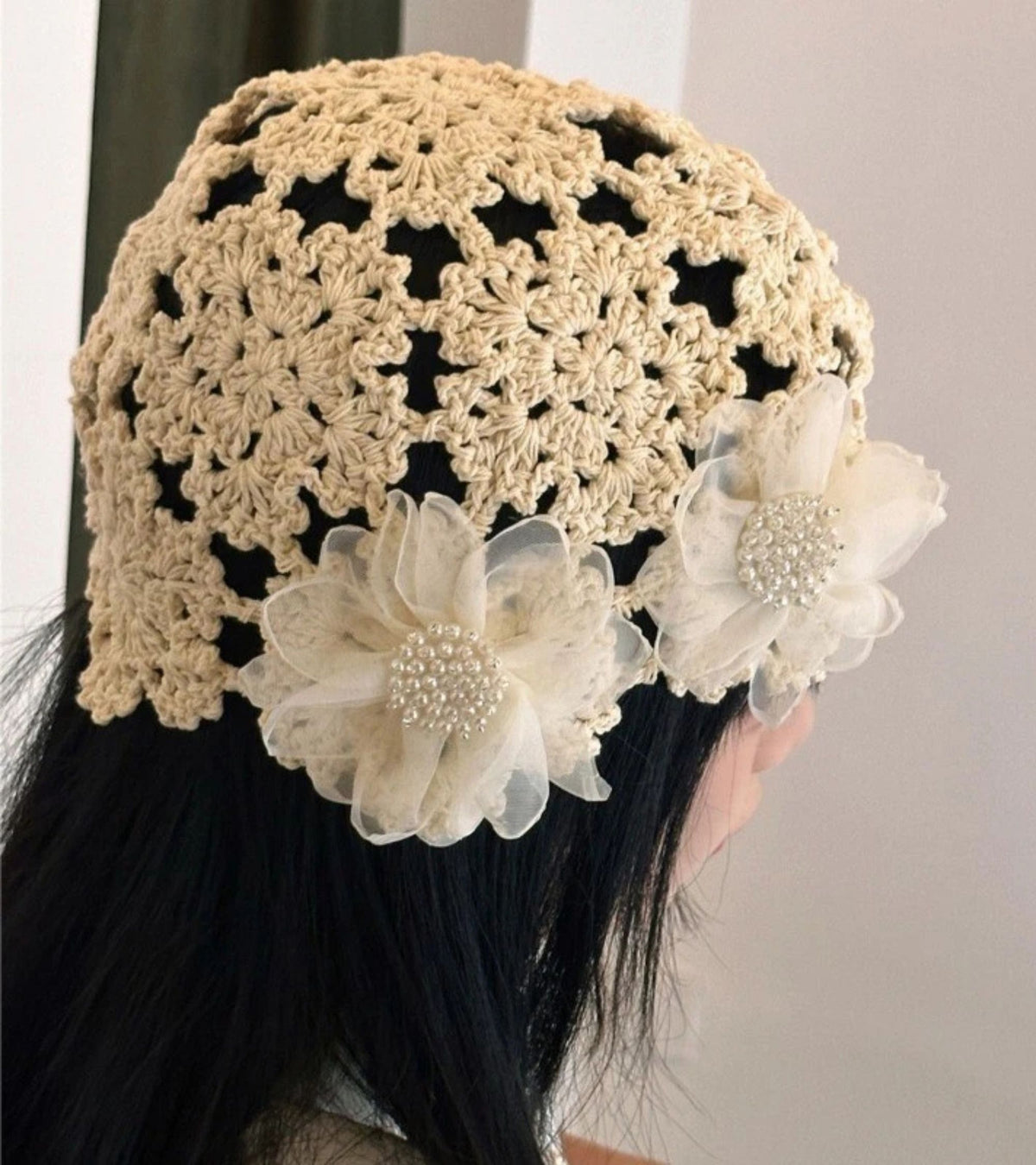 Cream crochet lace bucket cap with openwork stitch pattern and organza flower accents