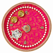 Round pooja thali with pink floral pattern, gold rim and border, pearl edge, gold and silver accents.