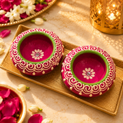 Decorative wax diya set with pink scalloped borders and green center, white flower motif