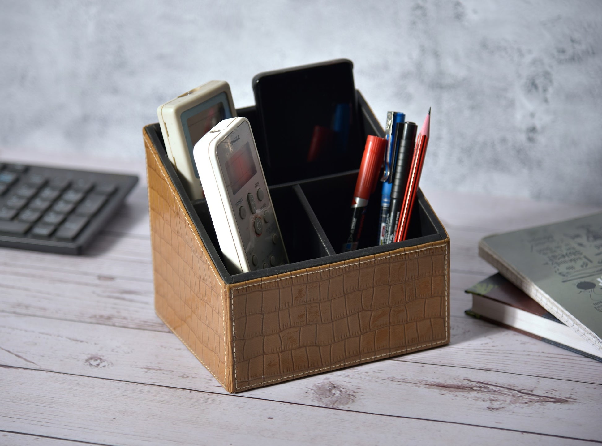 Croc-pattern remote holder with 3 compartments, brown, holding devices and pens.