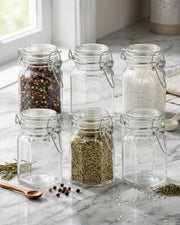 Glass storage jar set with clip-top lids, filled with spices and dried herbs
